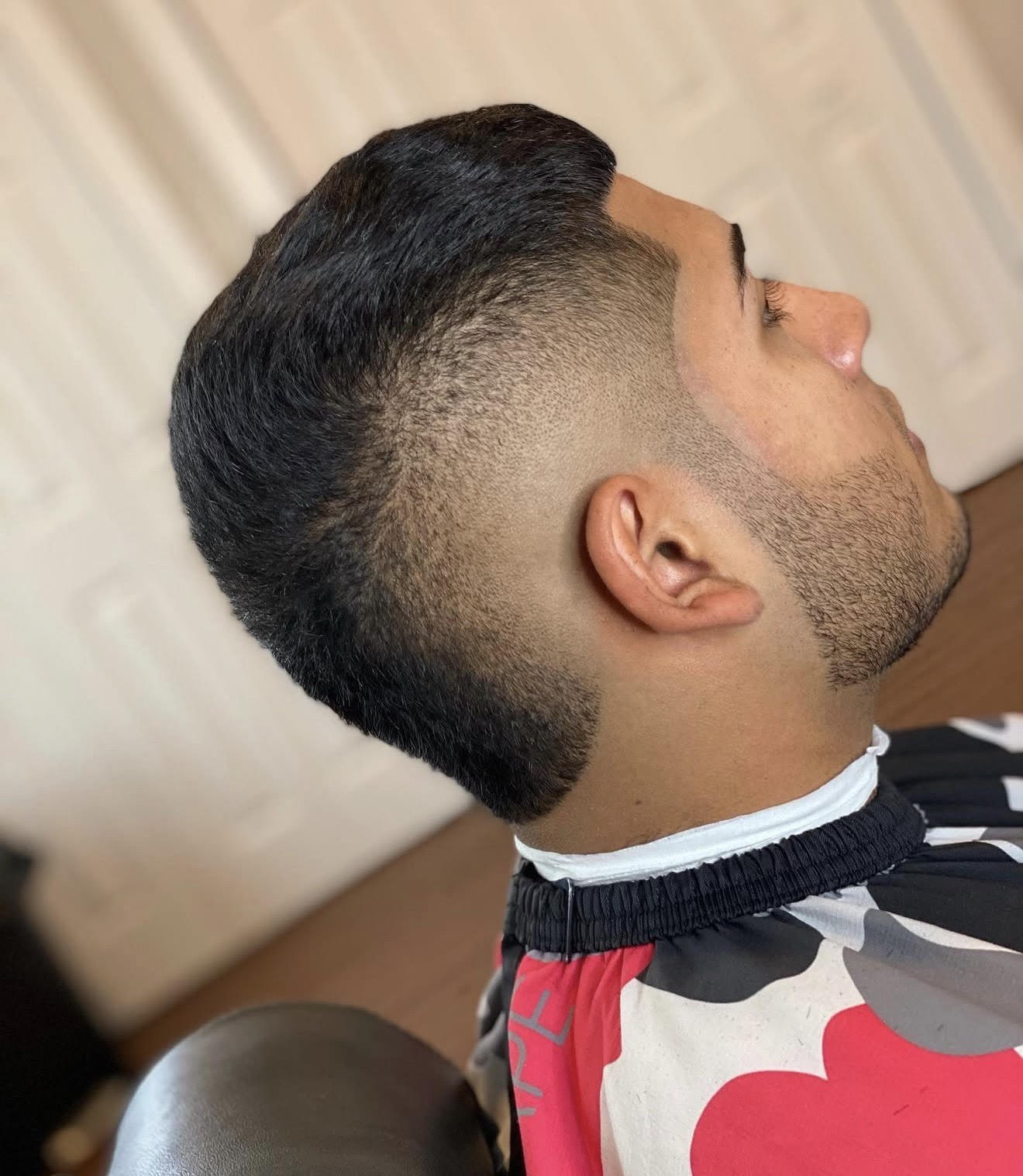 Client side profile showing a precision skin fade with a textured crop top, clean beard lineup, and sharp edge work done at Clean Cut Studio barbershop in Brockport NY